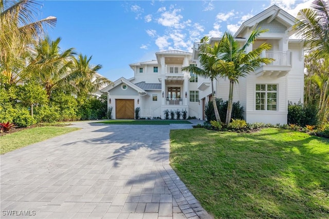 mediterranean / spanish-style house with a balcony, a front yard, and a garage