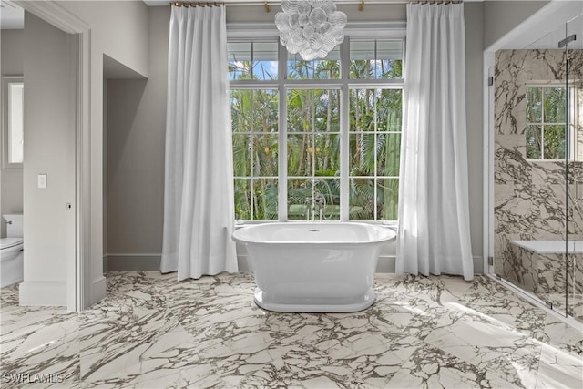 bathroom with toilet, a chandelier, and a bathtub