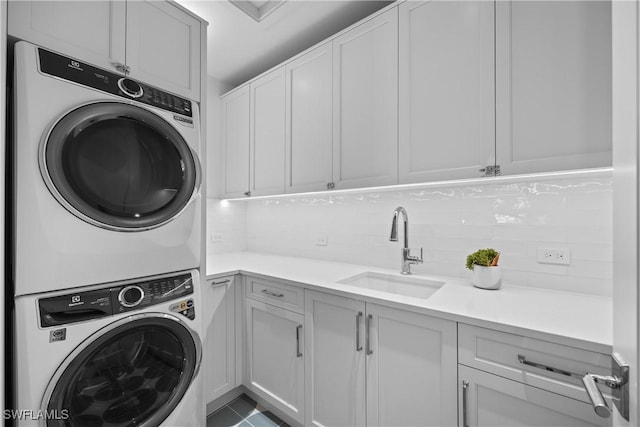 washroom with stacked washing maching and dryer, sink, and cabinets