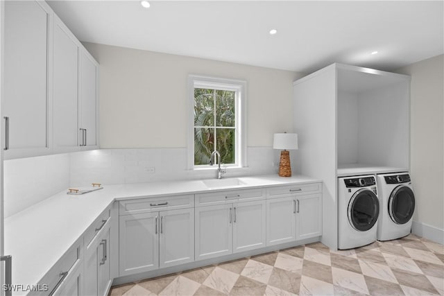 laundry area featuring washer and dryer, sink, and cabinets