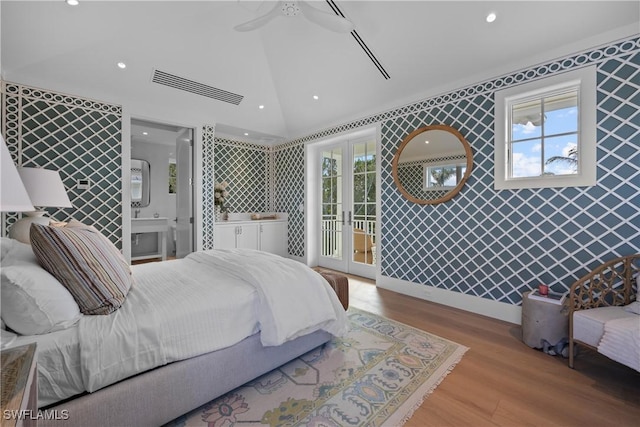 bedroom with ensuite bathroom, ceiling fan, access to exterior, vaulted ceiling, and light hardwood / wood-style flooring