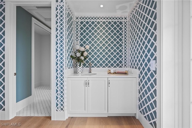 bathroom with vanity, ornamental molding, and hardwood / wood-style floors