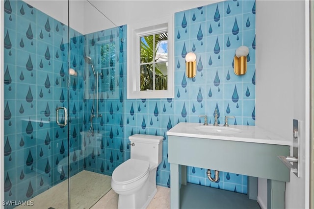 bathroom with toilet, a shower with door, tile patterned flooring, tile walls, and vanity