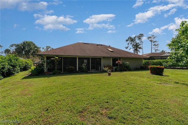 rear view of property featuring a lawn and a sunroom