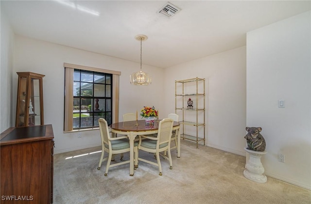 dining space with carpet flooring and a notable chandelier