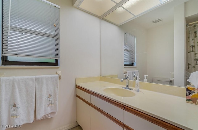 bathroom featuring vanity, toilet, and curtained shower