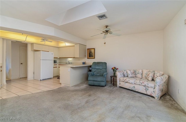 carpeted living room with ceiling fan and sink