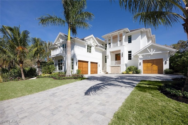 view of front of house with a garage, a balcony, and a front lawn