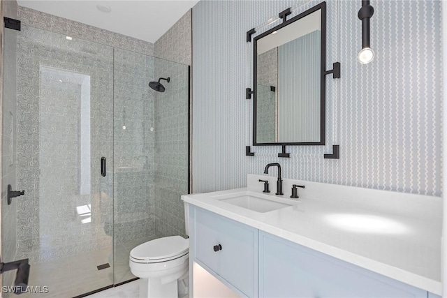 bathroom with vanity, toilet, and a shower with shower door