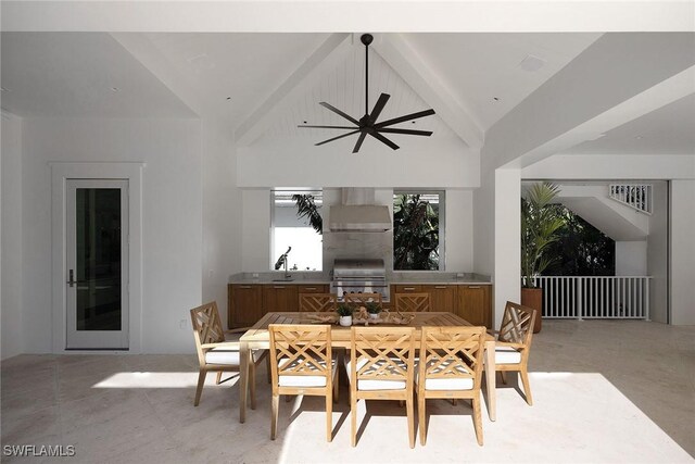 dining room with ceiling fan, sink, and lofted ceiling with beams