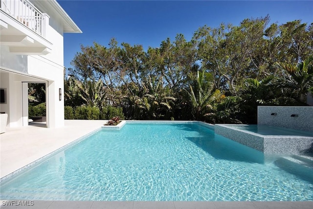 view of swimming pool featuring a patio area and a hot tub