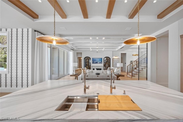 kitchen featuring beamed ceiling and hanging light fixtures