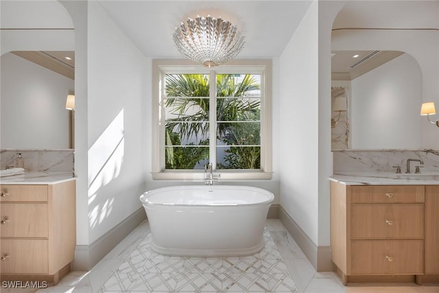 bathroom featuring vanity, a bathtub, crown molding, and an inviting chandelier