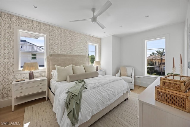 bedroom with ceiling fan, light wood-type flooring, and crown molding