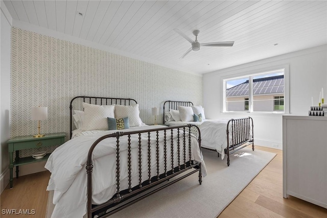 bedroom featuring ceiling fan, wooden ceiling, crown molding, and light hardwood / wood-style flooring