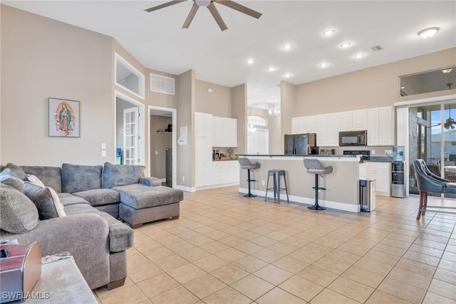 tiled living room with a high ceiling and ceiling fan