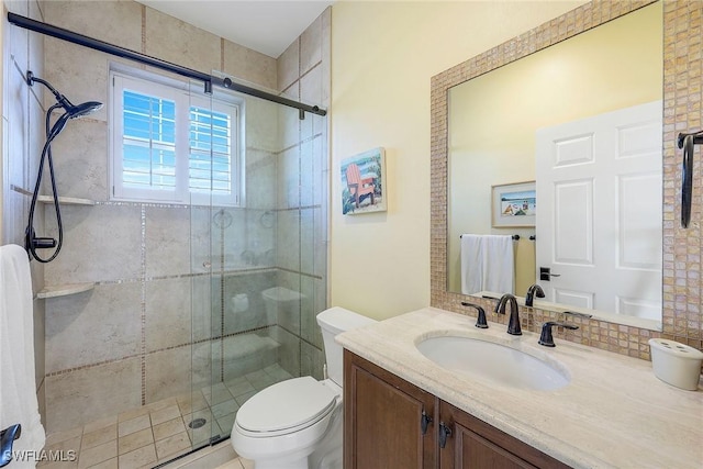 bathroom featuring vanity, toilet, and a shower with shower door