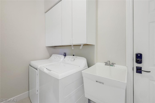 washroom featuring cabinets, sink, and washing machine and dryer