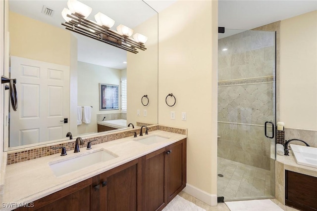 bathroom featuring tile patterned floors, vanity, and shower with separate bathtub