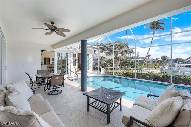 view of pool with ceiling fan, a patio area, an outdoor hangout area, and glass enclosure