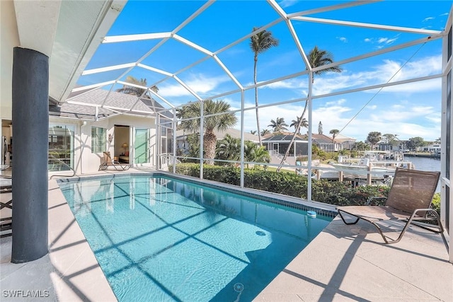 view of pool with a lanai, a water view, and a patio