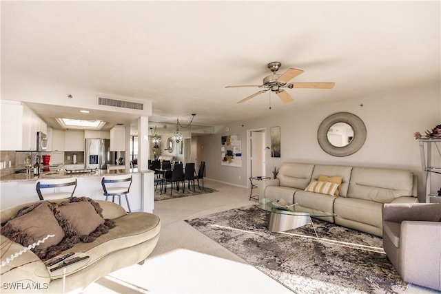 living room featuring a skylight and ceiling fan