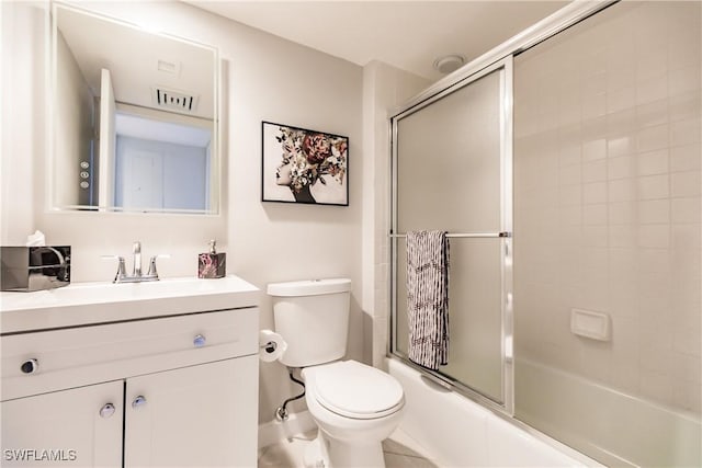 full bathroom with tile patterned floors, vanity, enclosed tub / shower combo, and toilet