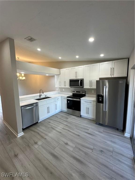 kitchen with white cabinets, appliances with stainless steel finishes, light hardwood / wood-style floors, and sink