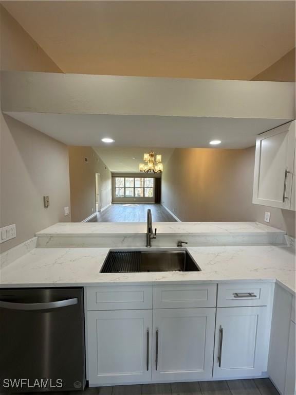 kitchen with light stone counters, sink, a notable chandelier, dishwasher, and white cabinetry