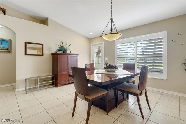 tiled dining room featuring lofted ceiling