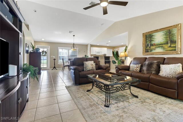 tiled living room featuring ceiling fan and vaulted ceiling