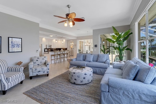 tiled living room featuring ceiling fan with notable chandelier and crown molding