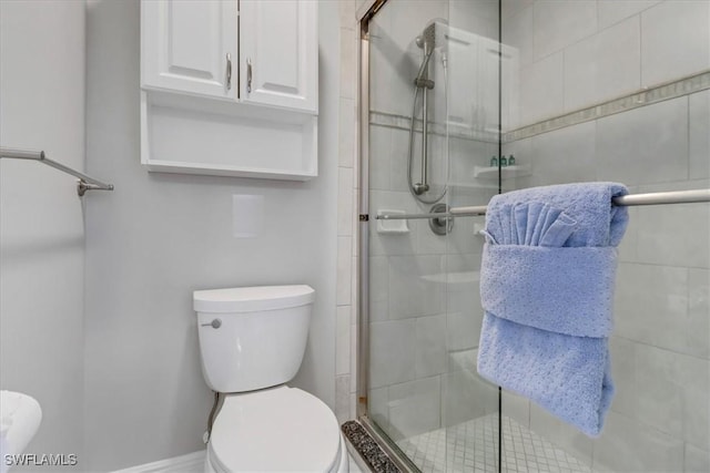 bathroom with toilet and an enclosed shower