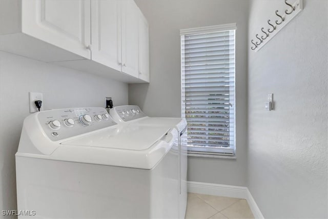 laundry area featuring washer and dryer, cabinets, and light tile patterned floors