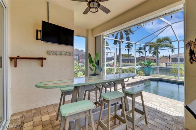 view of pool with ceiling fan, a patio, and glass enclosure