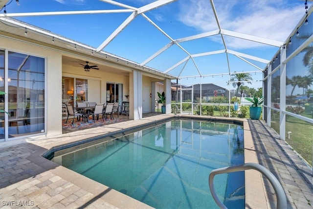 view of swimming pool with a lanai, ceiling fan, and a patio area