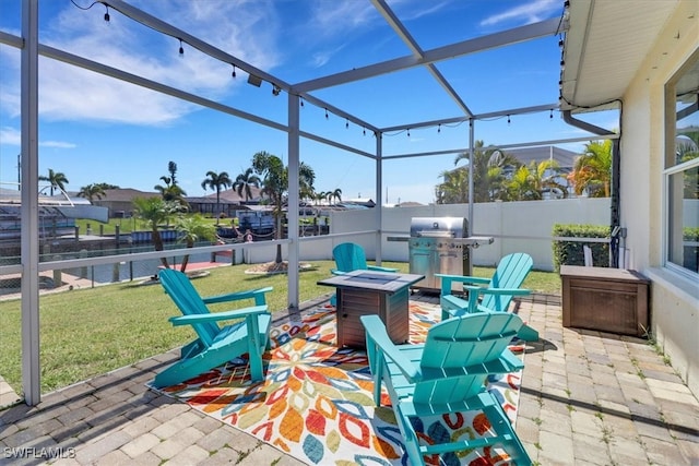 view of patio featuring glass enclosure, a fire pit, and grilling area