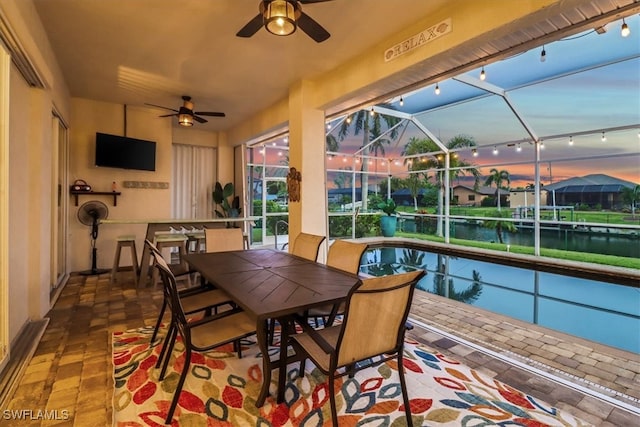 sunroom featuring ceiling fan, a water view, track lighting, and a pool