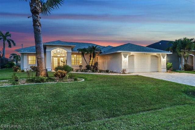 ranch-style house with a garage and a yard