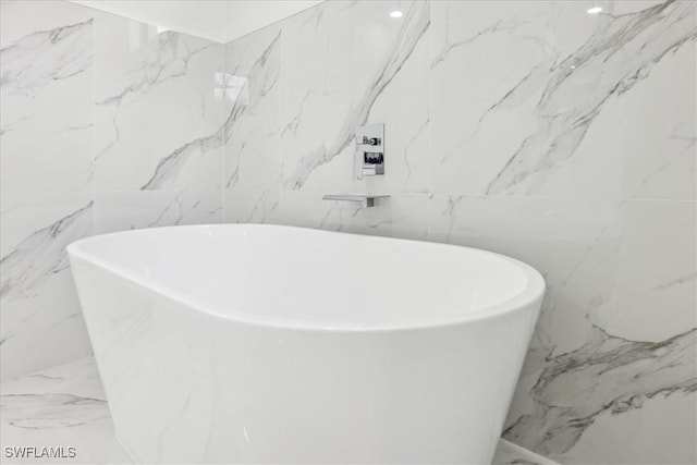 1436 Graham Cir, Lehigh Acres, FL 33936 - bathroom with tile walls, a soaking tub, and marble finish floor
