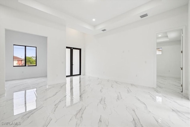 empty room with a raised ceiling and french doors