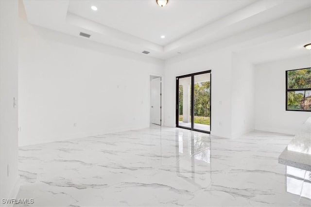 1436 Graham Cir, Lehigh Acres, FL 33936 - empty room featuring a raised ceiling, visible vents, marble finish floor, and a wealth of natural light