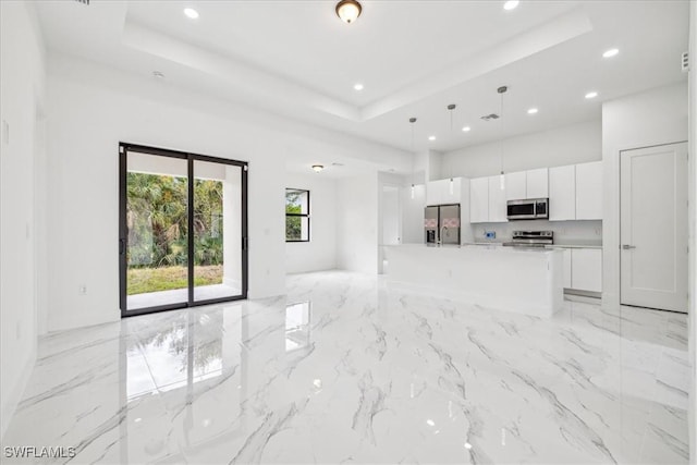 unfurnished living room featuring a tray ceiling