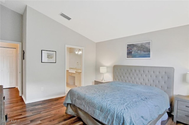 bedroom featuring dark hardwood / wood-style floors, connected bathroom, and vaulted ceiling