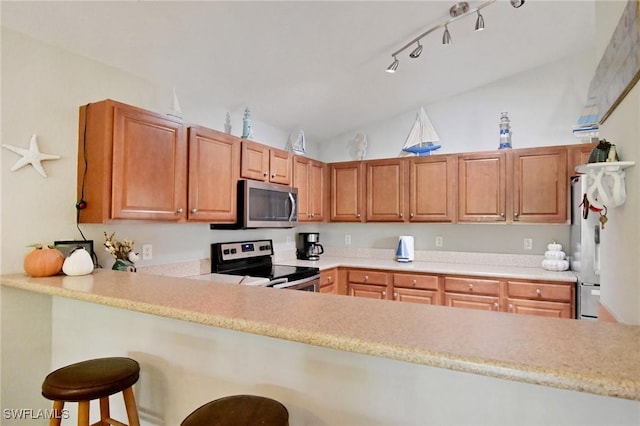 kitchen with lofted ceiling, stainless steel appliances, and a breakfast bar area