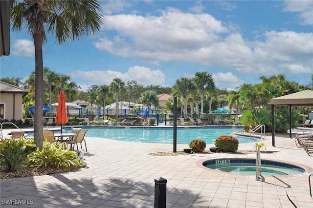 view of swimming pool with a community hot tub and a patio area