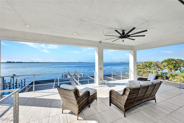 view of patio with ceiling fan, a balcony, and a water view