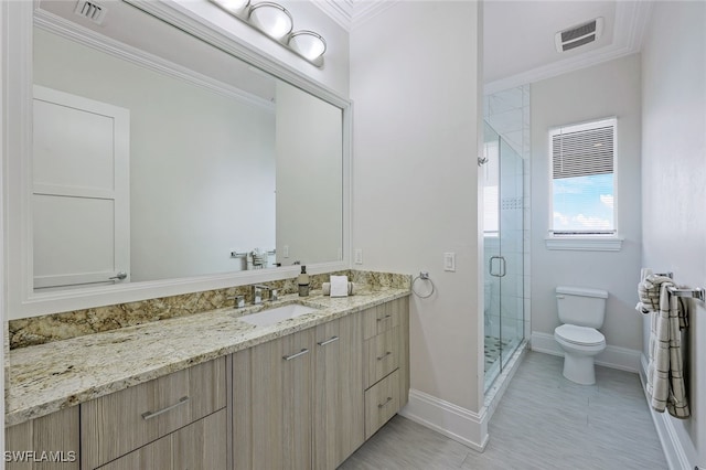 bathroom featuring crown molding, vanity, an enclosed shower, and toilet