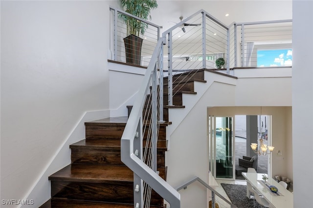 staircase with a chandelier and a healthy amount of sunlight