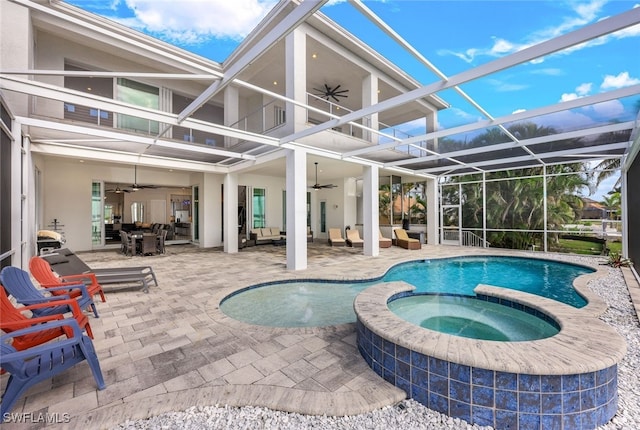 view of pool with an in ground hot tub, a lanai, outdoor lounge area, ceiling fan, and a patio area